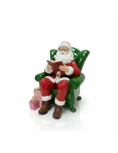 Babbo natale su poltrona con libro